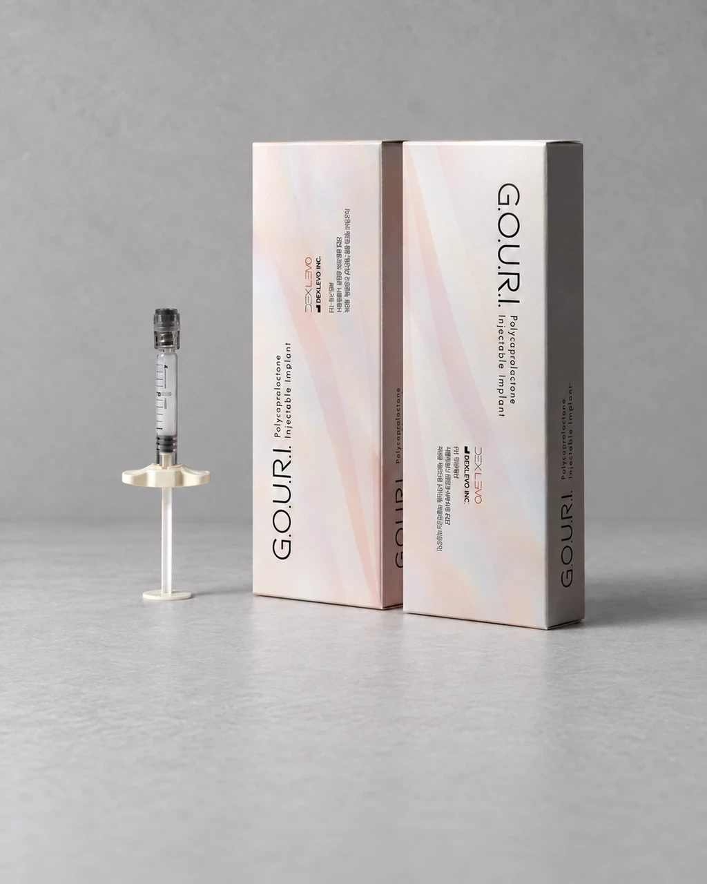 浅灰色背景上的GOURI银色包装与注射器